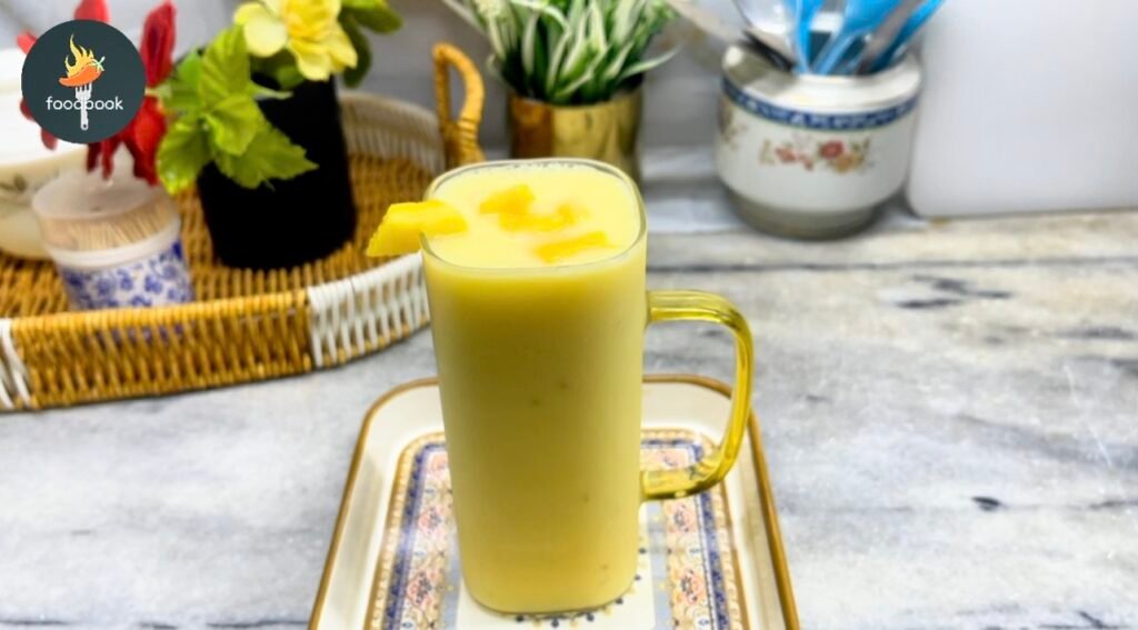 Chilled Mango Milkshake served in a glass with mango chunks on top