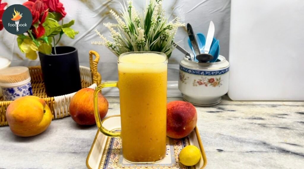 Glass of homemade peach lemonade with ice and fresh peach slices on a wooden table.